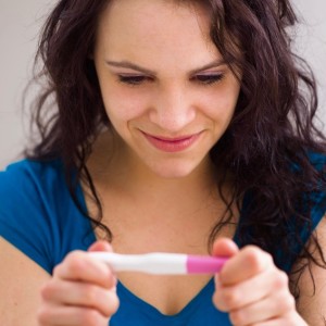 Young Woman Smiling at a Pregnancy Test